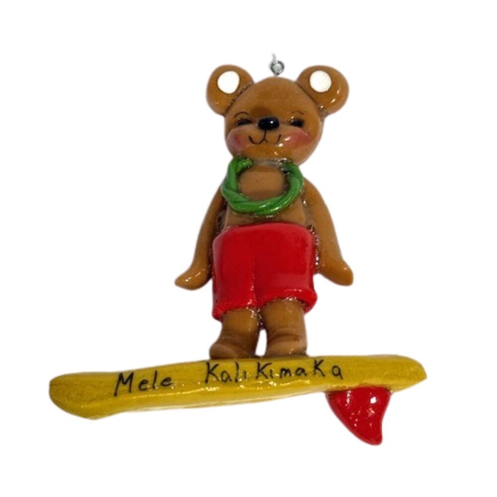 Hawaiian bear on surfboard Christmas ornament. Says Mele Kalikimaka.